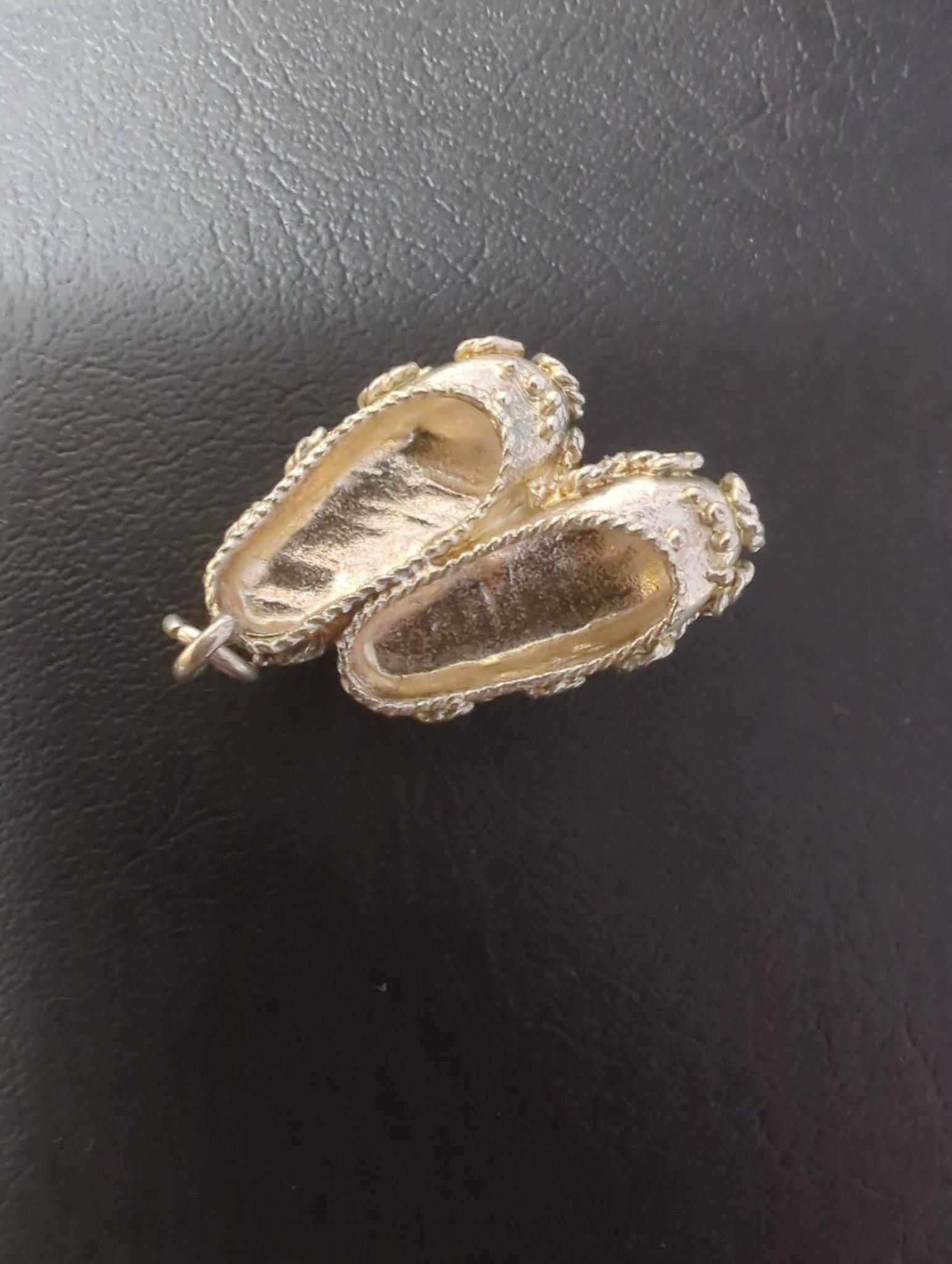 An Edwardian silver miniature model of an occasional chair, import marks for London, 1902, 43mm, a continental white metal model of a shoe and a similar model of a young child, a base metal 'book' box containing a rosary